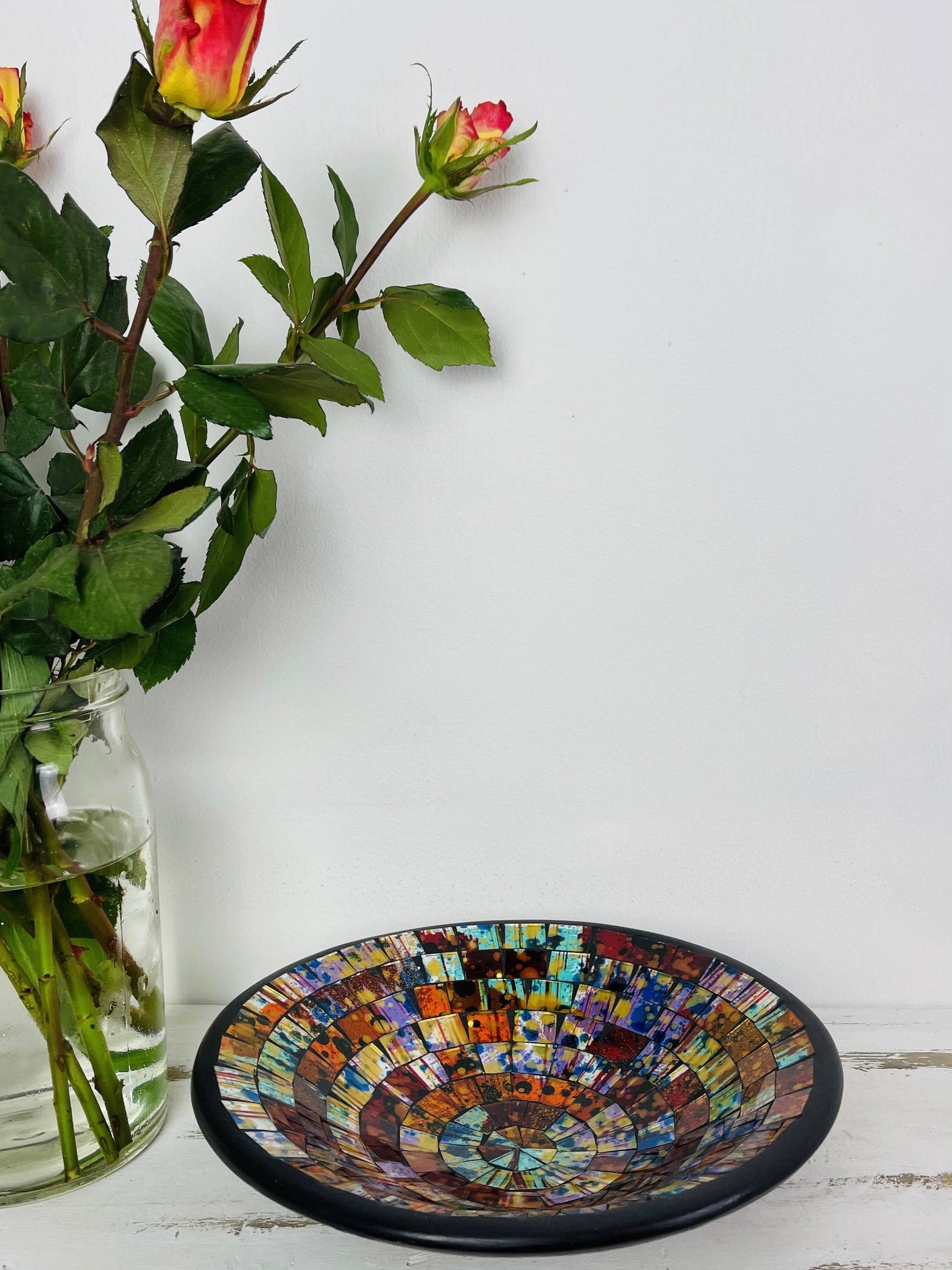mosaic bowl front view with a vase of flowers next
