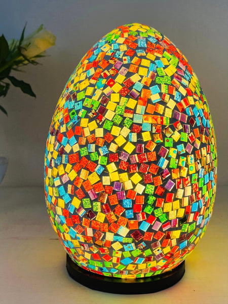 front view of mosaic egg lamp with light on on white surface